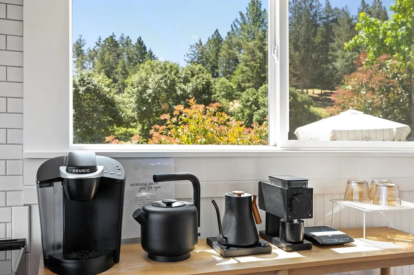 Coffee bar with pour-over kettle and grinder beneath a garden window
