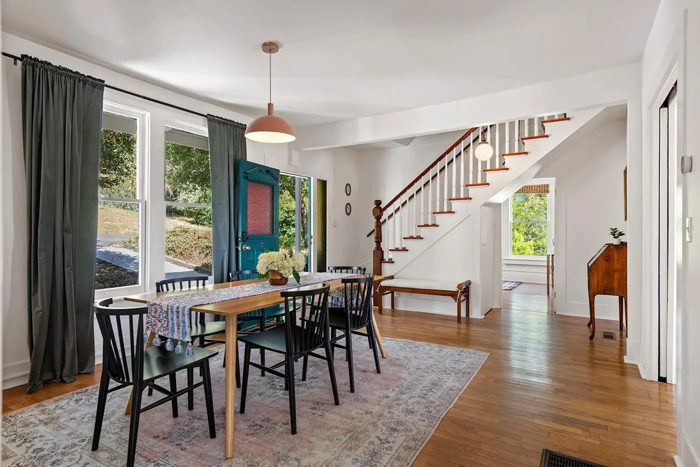 Dining room with long wood table and the staircase beyond